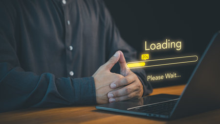 Person waits with a laptop screen displaying a "Loading" bar at 20%, accompanied by the text "Please Wait." Concept of digital processes, patience, and the anticipation of technology responding.の写真素材