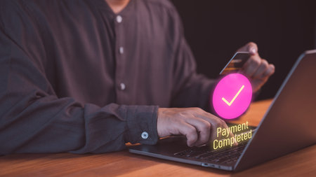 Person completing an online payment using a credit card on a laptop, with a glowing check mark and...