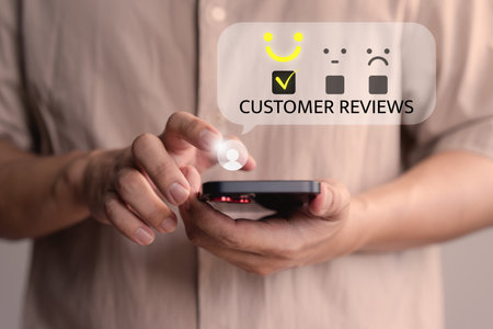 Male member using a smartphone select a happy face icon from a feedback. Business concept of customer service satisfaction, review, and positive user experience in an online feedback system.の写真素材