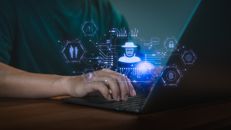 Male hands typing on a laptop computer with digital icons of a hacker and cybersecurity symbols. Concept of online privacy, representing cybercrime, data theft, and online security threats.の写真素材