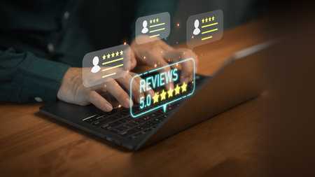 Hands typing on laptop computer with glowing 5 star review icons, symbolizing positive customer...