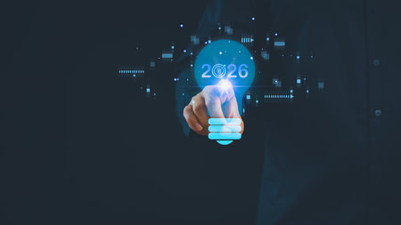 Futuristic business concept showing hand businessman pointing to glowing light bulb with 2026...