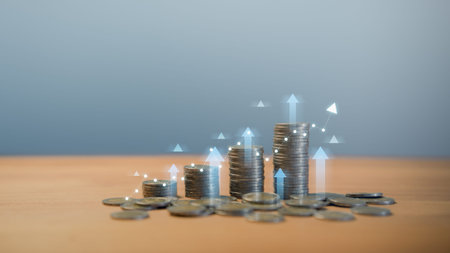 Stacks of coins with glowing upward arrows and graph line, symbolizing financial growth, investment...