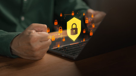 Person working on laptop with digital lock icon, illustrating cybersecurity protection, data...
