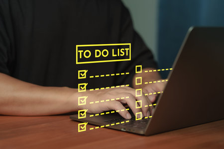 Person using laptop with To Do List checklist interface, symbolizing productivity, task management,...