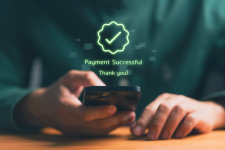 Person holding smartphone with digital confirmation message â€œPayment Successful,â€...