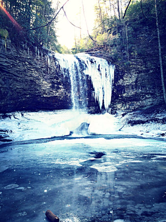 Water flowing over a cliff frozen in time above a mirror created by Mother Nature の素材