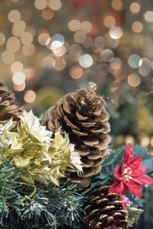 Christmas Decoration Garland with Poinsettia Pine Cones and Colorful Blurred Bokeh Lights Backgroundの写真素材