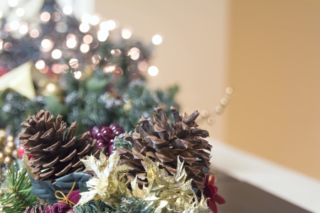 Christmas Decoration Garland with Poinsettia Pine Cones and Blurred Bokeh Lights Backgroundの写真素材