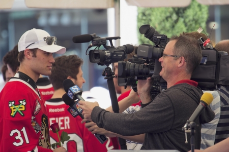 PORTLAND, OREGON, MAY 14 2013: Portland Winterhawks Ice Hockey Team members being interviewed by Television Station at Pioneer Square Rally on May 14, 2013, after winning the Western Hockey League Championship and bringing home the Ed Chynoweth Cupのeditorial素材