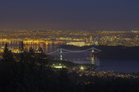 Vancouver BC Canada Cityscape with Stanley Park and Lions Gate Bridge Over Burrard Inlet at Evening Blue Hourの写真素材