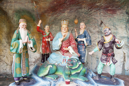 SINGAPORE - FEBRUARY 1, 2014  Di Zang Wang Ksitigarbha Buddha, in charge of the Tenth Court of Hell, with Attendants Statues Diorama at Haw Par Villa Theme Parkのeditorial素材