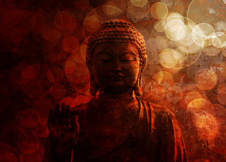 Bronze Zen Buddha Statue Raised Palm with Blurred Textured Red Backgroundの写真素材