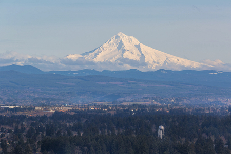 Snow covered Mount Hood view with water tower in the landscape on a sunny dayの写真素材