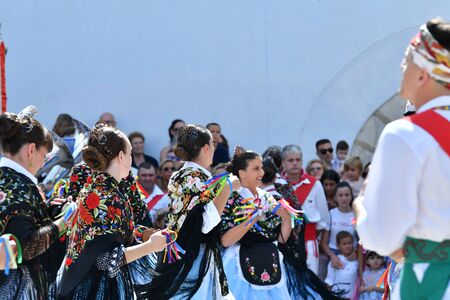 Peniscola, Castellon, Spain, September 08, 2019: Beautiful and charming women dressed in traditional dresses and beautiful hairstyles celebrate the patron saint festival of Peniscola dancing on a sunny day. Concept of cultural celebration. Colorful photoのeditorial素材