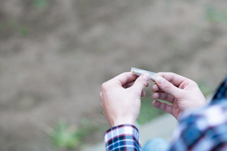 Two hands rolling a cigarette with a selective focus. Close-up