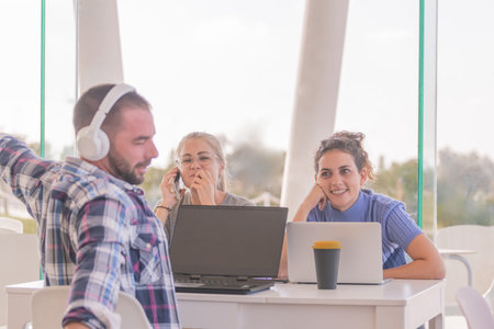 Friendly girls sitting while sharing a table with a man who is in profile to the camera while...