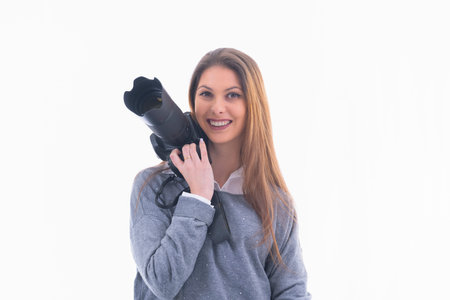 Smiling photographer holding a camera next to her face