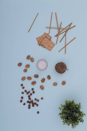 Glass of milk with assorted nuts and crackersの写真素材