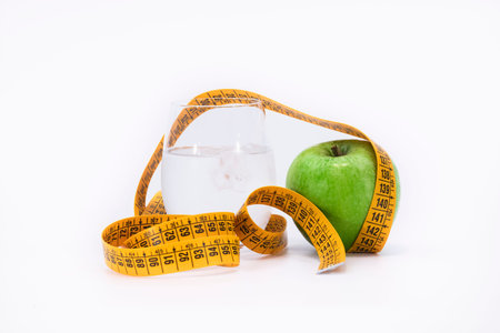 yellow tape measure and a green apple