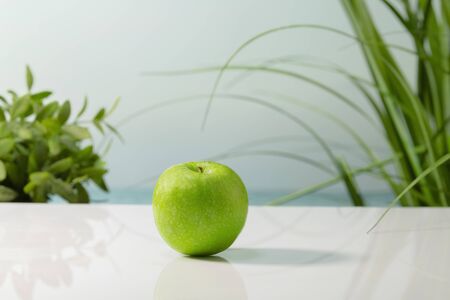 Close up of a delicious looking green apple on a table on an out of focus background. Healthy and vegan food concept.の写真素材