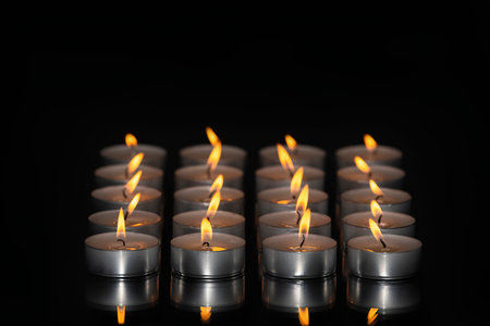 Select focus of an artistic arrangement of lit tea light candles. Relaxation and abstract concept.