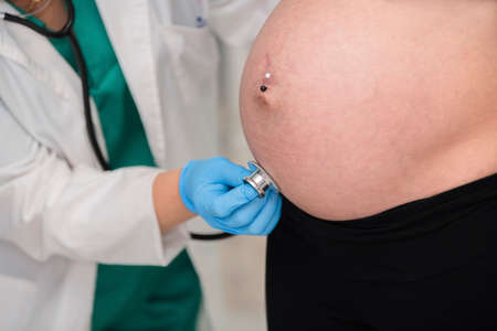 Doctor checking a pregnant woman with a stethoscopeの写真素材