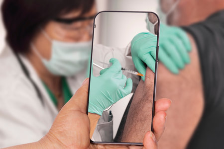 Taking a picture of man getting vaccinatedの写真素材
