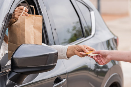 Females exchanging a credit card through a car window