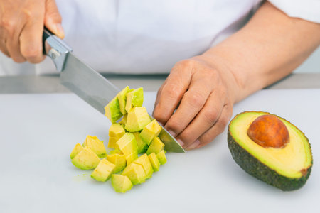 Avocado freshly cut into dice with a kitchen knife