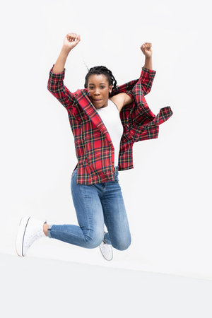 Jumping afro american woman with her arms raised