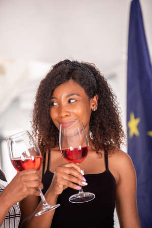 African American woman in a meeting having a glass of red wineの写真素材