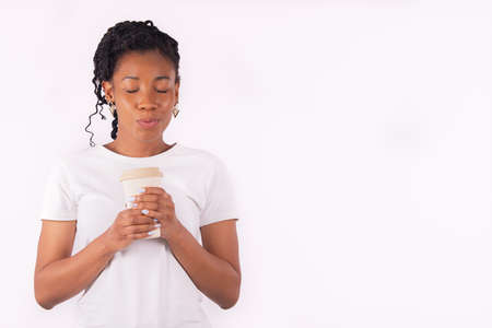 Afro american woman holding a paper cup doing a kissing gestureの写真素材