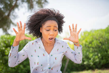 Young shocked woman looking down with a surprised expression on her face.の写真素材