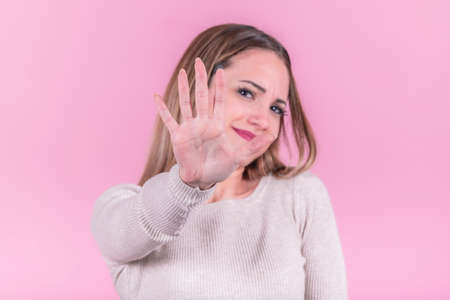 Woman doing a stop gesture to the cameraの写真素材