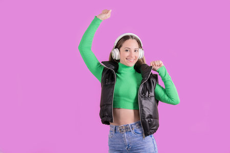Energetic woman wearing headphones raising her arm