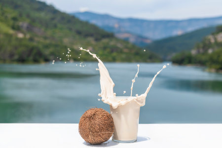 Close up of splashing coconut shake with a whole coconutの写真素材
