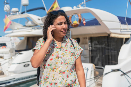 Woman talking on her phone near a boat. Selective focus. Holidays and technology concept.