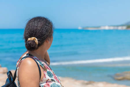 Woman of Moroccan origin looking at an out of focus sea. New generation conceptの写真素材