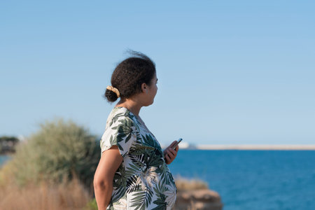 Relaxed pregnant woman looking at the seaの写真素材