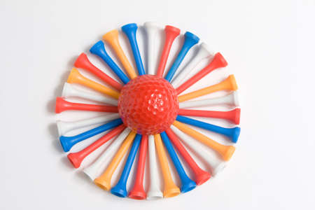 Golf ball surrounded by colored teesの写真素材