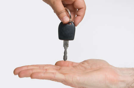 A hand giving the keys of a car to anotherの写真素材