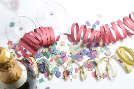 Two glasses of champagne surrounded by confetti and champagne bottleの写真素材