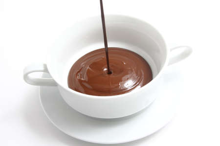 Dropping melted chocolate in a cupの写真素材