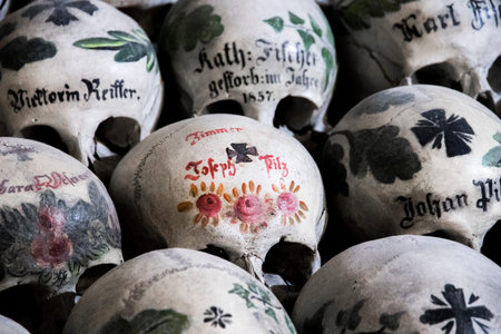 Skulls painted with names, colorful flowers and crosses in the Charnel House or Beinhaus, Hallstatt, Austriaの写真素材