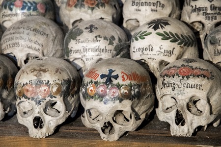 Skulls painted with names, colorful flowers and crosses in the Charnel House or Beinhaus, Hallstatt, Austriaの写真素材