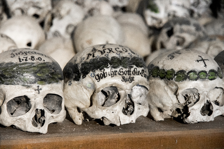Skulls painted with names, colorful flowers and crosses in the Charnel House or Beinhaus, Hallstatt, Austriaの写真素材