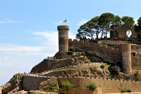 A Senyera estelada, the unofficial flag typically flown by Catalan independence supporters, waving on the tower of Tossa de Mar Fortress, Catalonia, Spainのeditorial素材