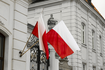 Waving flags of Poland in the wall of a palace in Warsawのeditorial素材