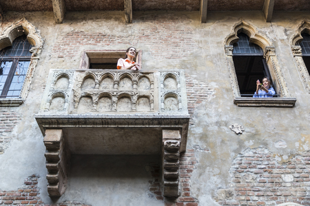 Two tourist girls making pictures in the balcony that inspired the tragedy Romeo and Juliet written by William Shakespeare. Casa di Giulietta, Verona, Italyのeditorial素材